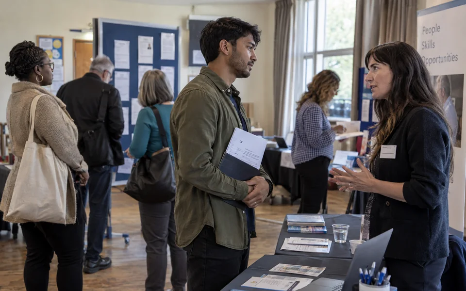Job seekers and recruiters talking at a small career fair.